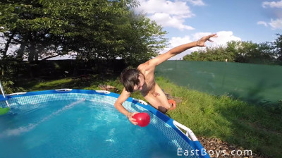 Twee naakte atletische jongens spelen samen in het zwembad