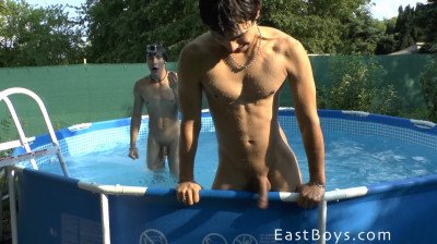 Twee naakte atletische jongens spelen samen in het zwembad