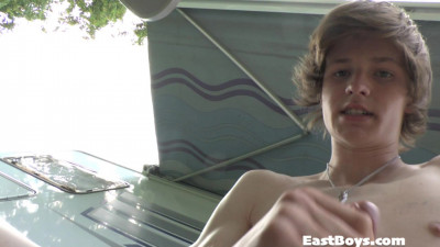 Kleine jongen zit aan zijn piemel op de camping